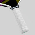 Close-up of a pickleball paddle handle with white grip and black 'Grizzlee' branding on a gray background