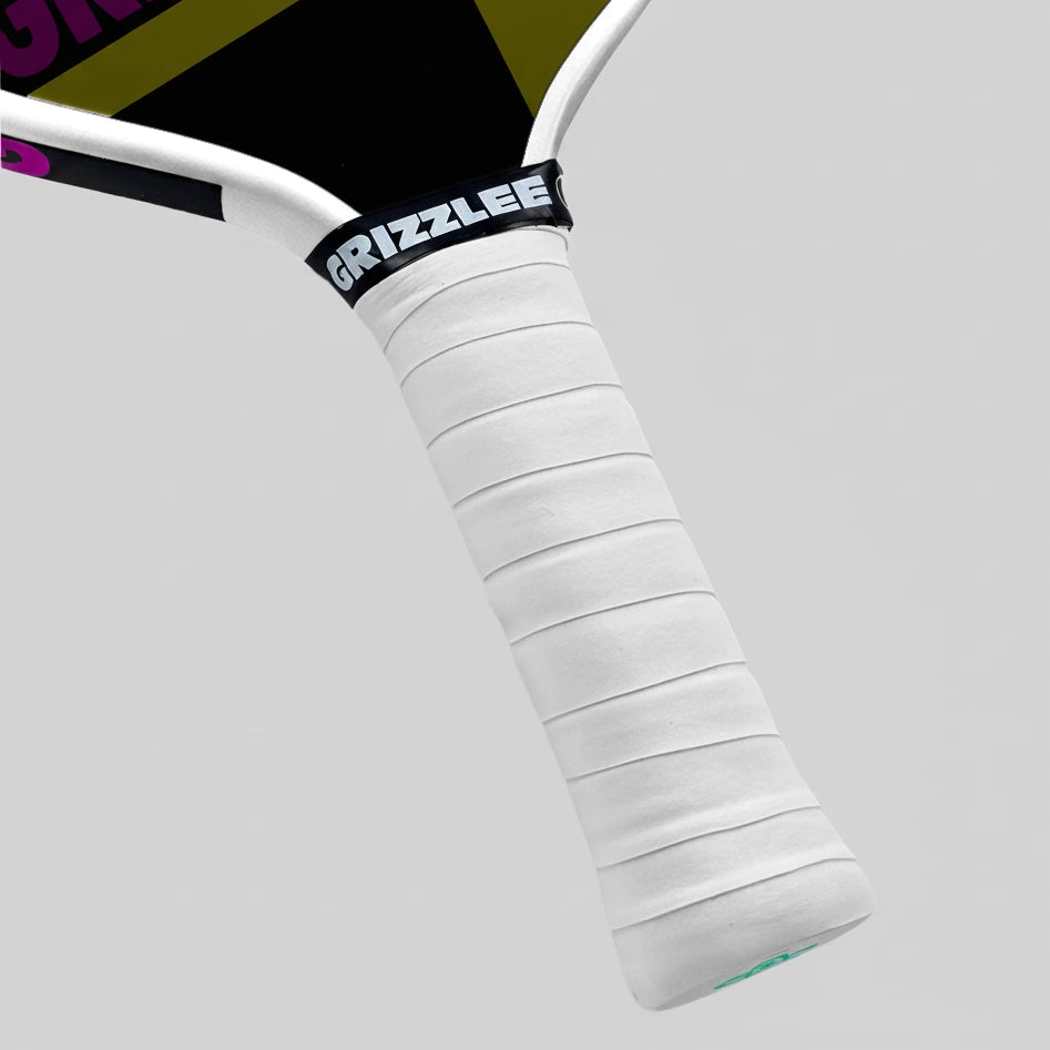 Close-up of a pickleball paddle handle with white grip and black 'Grizzlee' branding on a gray background