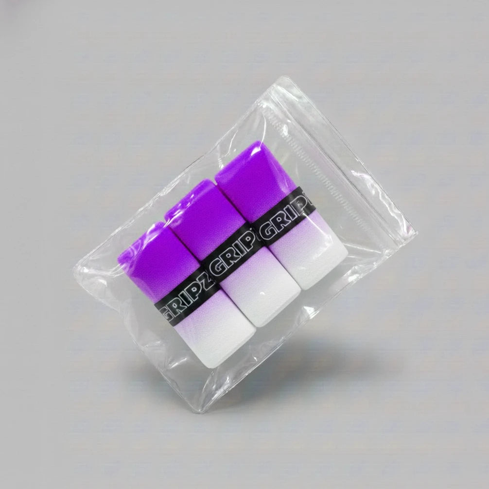 Grizzlee Gripz Packaged purple and white pickleball overgrips on a gray background